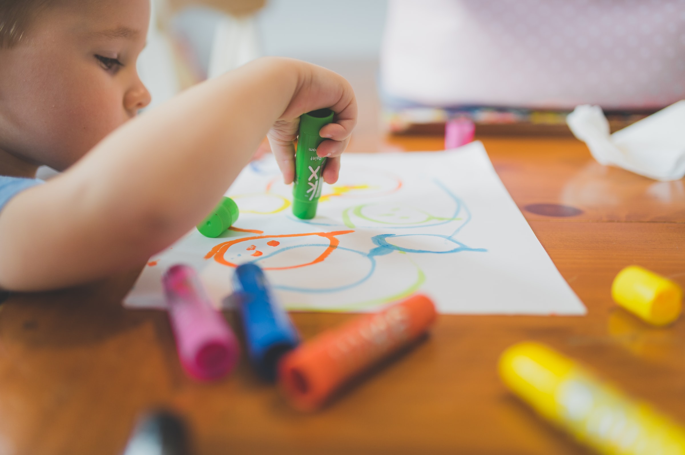 child coloring with paint sticks