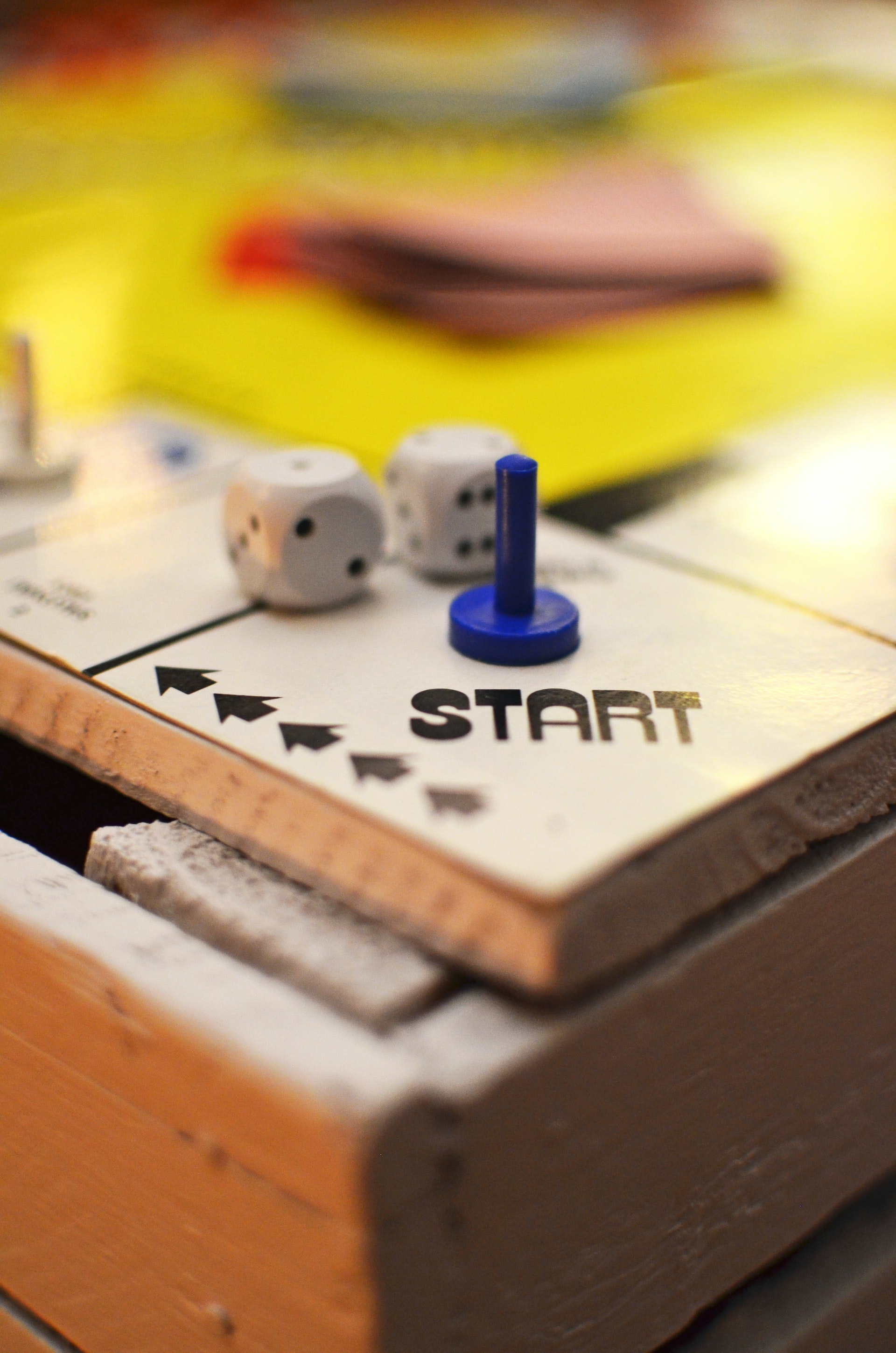 a die and a game piece on the "start" square of a board game